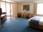 シェラトン・ミラージュポートダグラスリゾート（オーストラリア・ポートダグラス）の部屋のリビングスペースとベッド